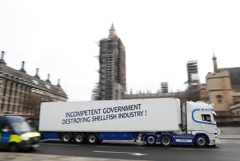 A shellfish export lorry with a protest sign written across the trailer drives past the Palace of Westminster in London. AP Photo