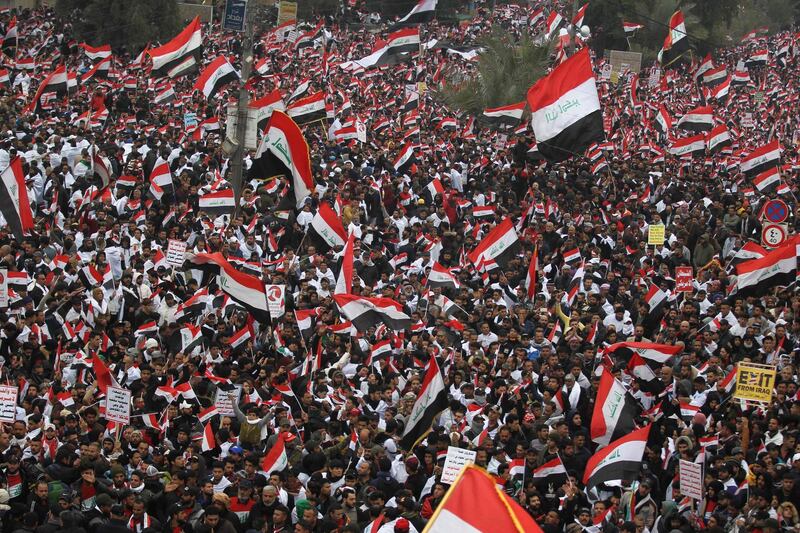 Thousands of Iraqis, waving national flags, take to the streets in central Baghdad on January 24, 2020 to demand the ouster of US troops from the country. Thousands of supporters of volatile Iraqi cleric Moqtada Sadr gathered in the Iraqi capital on Friday for a "million-strong" march to demand an end to the presence of US forces in Iraq, putting the protest-hit capital on edge. The march has rattled the separate, months-old protest movement that has gripped Baghdad and the Shiite-majority south since October, demanding a government overhaul, early elections and more accountability. / AFP / AHMAD AL-RUBAYE
