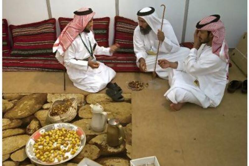 Men discuss the quality of the dates at the Ajman-Liwa Date Festival in Ajman.