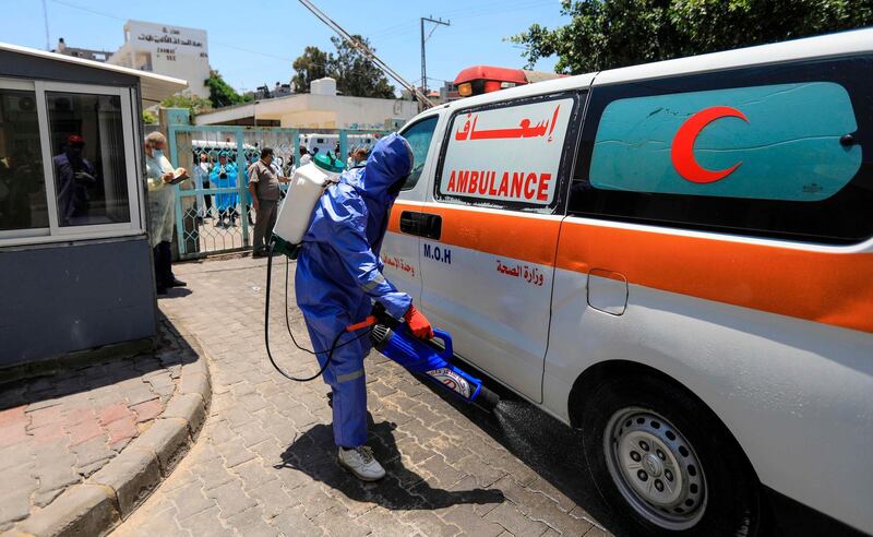 A Palestinian medical worker disinfects an ambulance at a hospital in Gaza City.  AFP