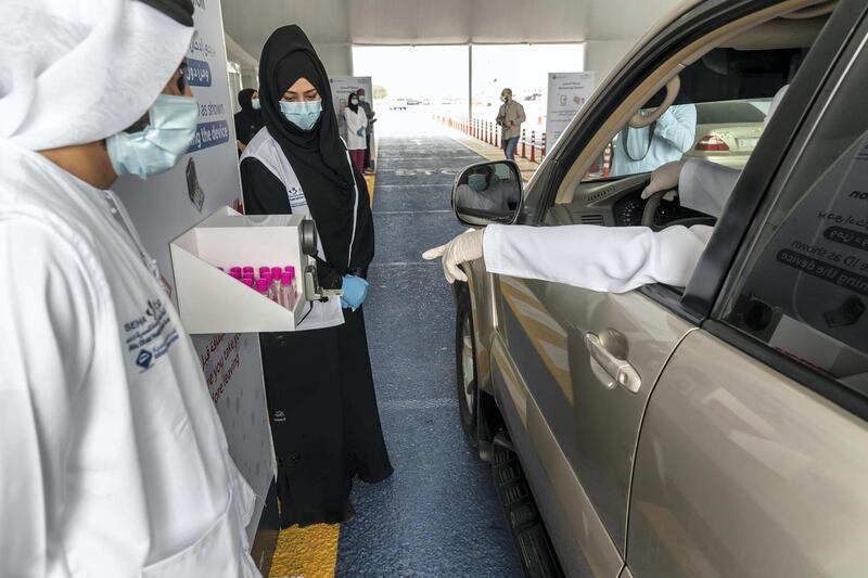 RAS AL KHAIMAH, UNITED ARAB EMIRATES. 12 APRIL 2020. The Ras Ak Khaimah National Screening Center in RAK city that forms part of the drive-through testing centres that opened across the emirates last week. A manuses his Emirates ID card to register before the actual test. (Photo: Antonie Robertson/The National) Journalist: Ruba Haza. Section: National.