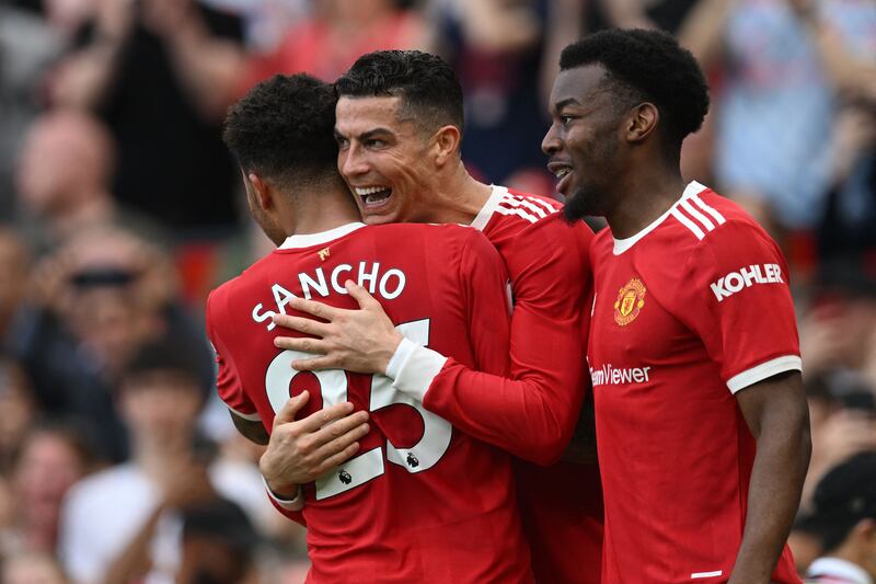 Manchester United's Cristiano Ronaldo celebrates with Jadon Sancho after completing his hat-trick in the 3-2 victory over Norwich at Old Trafford on April 16. AFP