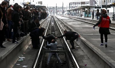Commuters help a woman who fell onto the railway tracks at Gare de Lyon train station in Paris during a nationwide strike by French SNCF railway workers, France, April 3, 2018. REUTERS/Gonzalo Fuentes