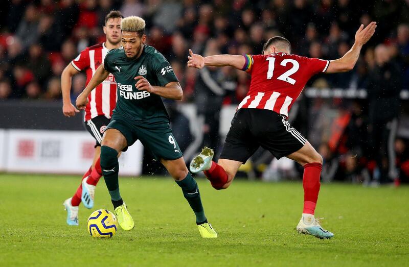 SHEFFIELD, ENGLAND - DECEMBER 05: John Egan (R) of Sheffield challenges Joelinton of Newcastle during the Premier League match between Sheffield United and Newcastle United at Bramall Lane on December 05, 2019 in Sheffield, United Kingdom. (Photo by Alex Livesey/Getty Images)