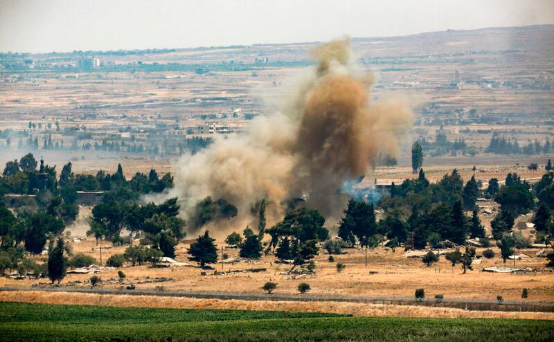 A picture taken on July 22, 2018 from the Israeli-annexed Golan Heights shows a smoke plume rising across the border in Quneitra in southwestern Syria, as rebels destroy their arms stocks prior to their departure. Rebel fighters and civilians began on July 20 evacuating from Quneitra province on their way to opposition territory further north in Idlib province under a surrender deal agreed between Russia and the rebels, seeing the sensitive zone fall back under state control. / AFP / JALAA MAREY
