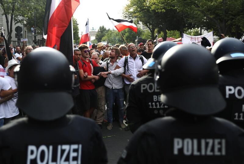 Demonstrators stand in front of the police officers during a rally against the government's restrictions following the coronavirus disease (COVID-19) outbreak, in Berlin, Germany, August 29, 2020. REUTERS/Christian Mang