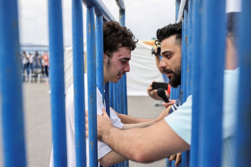 Mohammad, left, an 18-year-old Syrian rescued after the boat capsized, has an emotional reunion with his brother in Kalamata. Reuters