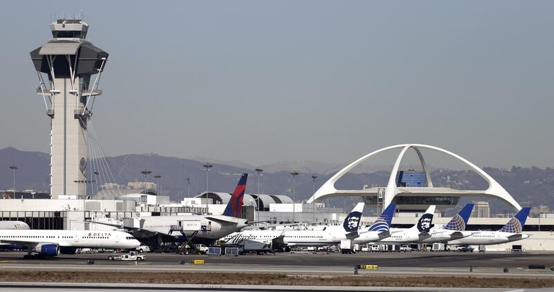 FILE - In this Nov. 1, 2013 file photo airplanes sit on the tarmac at Los Angeles International Airport. A Philippine Airlines jet with flames spurting from one engine has returned safely to Los Angeles International Airport shortly after takeoff. Ian Gregor of the Federal Aviation Administration says Flight 113, a Boeing 777 bound for Manila, reported a problem with the right engine after takeoff Thursday, Nov. 21, 2019. It turned around and landed safely at about noon. (AP Photo/Gregory Bull,File)