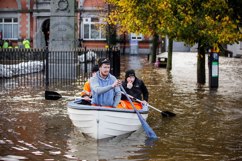 People canoe down a flooded road in Newry. AP