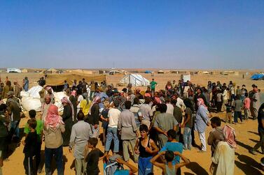 Residents of the Rukban camp near the Jordan-Syria border wait to receive aid. AP Photo