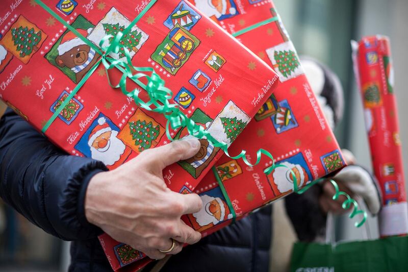 A man holding in his hands Christmas gifts that he recently bought in Stuttgart, Germany, 01 December 2017. Photo by: Sebastian Gollnow/picture-alliance/dpa/AP Images