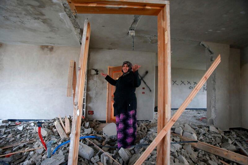 The mother of a Palestinian accused of killing a young Israeli woman, stands inside the damaged family home in West Bank town of Hebron. AFP