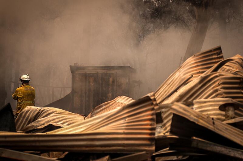 Firemen inspect a house recently destroyed by bushfires on the outskirts of the town of Bargo. Getty Images