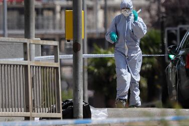 A police forensic officer works on a road near the scene of a fatal multiple stabbing attack in Reading, England. (AP Photo/Kirsty Wigglesworth)