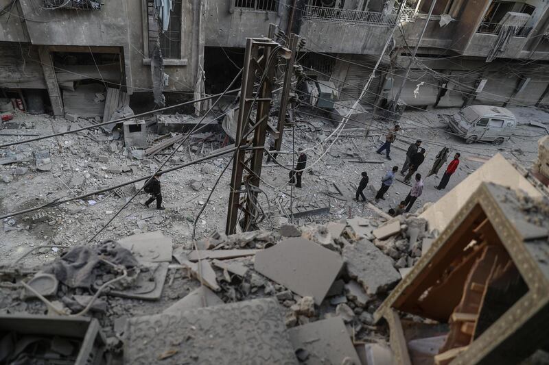 Men talk in a street covered in rubble after air strikes in Douma, Syria. Mohammed Badra / EPA