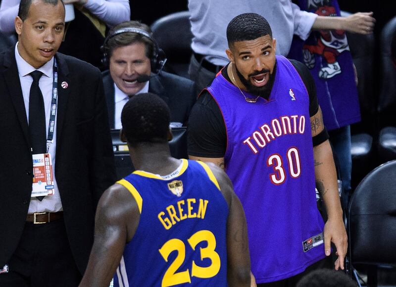 Rapper Drake, right, says something to Golden State Warriors forward Draymond Green (23) after the Toronto Raptors defeated the Warriors in Game 1 of basketball’s NBA Finals. AP Photo