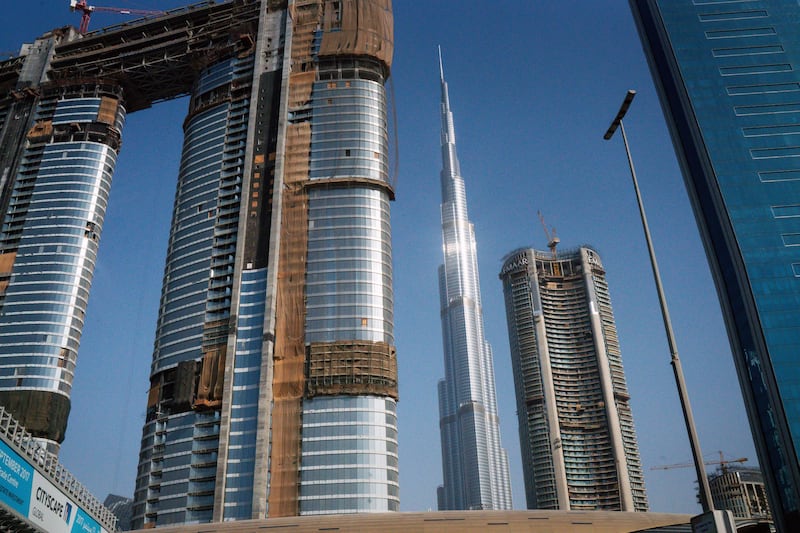The Burj Khalifa skyscraper, center, stands on the city skyline beyond new skyscrapers under construction in Dubai, United Arab Emirates, on Tuesday, Sept. 12, 2017. Dubai residential��property��prices and rents are set to fall further as losses of high-paying jobs and dwindling household incomes boost vacancies across the city, according to Phidar Advisory. Photographer: Tasneem Alsultan/Bloomberg