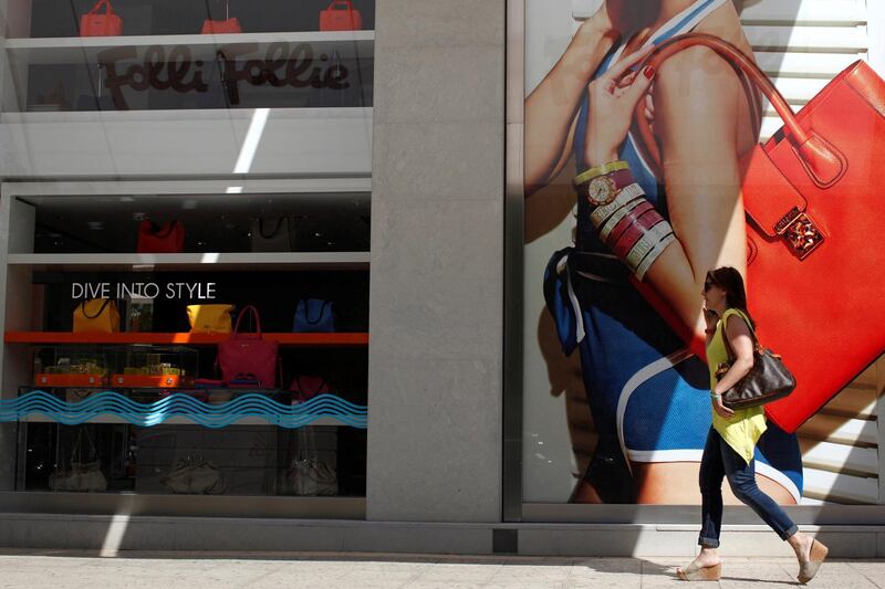 A pedestrian passes a display of women's handbags inside a Folli Follie SA store in the Glyfada district of Athens, Greece, on Monday, June 23, 2014. Dimitrios Koutsolioutsos, the founder and chairman of Folli Follie, has become a billionaire as the Athens-based maker of jewelry, handbags and fashion accessories increased almost 10-fold in the last two years. Photographer: Kostas Tsironis/Bloomberg