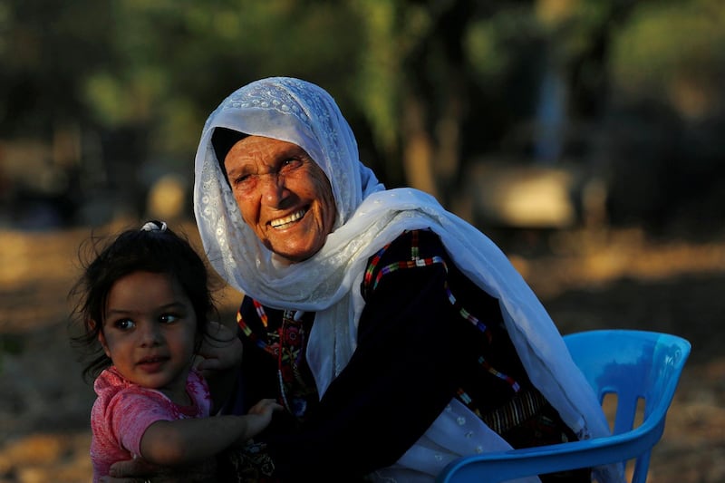 Muftia, the grandmother of U.S. congresswoman Rashida Tlaib, is seen with her granddaughter outside her house in the village of Beit Ur Al-Fauqa in the Israeli-occupied West Bank August 16, 2019. Picture taken August 16, 2019.  REUTERS/Mohamad Torokman