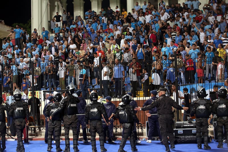 Security guards watch as supporters of Jordanian club Al Faisaly are involved in a fight during their Arab Club Championship final against Tunisian side Esperance de Tunis in Alexandria, Egypt, late on Sunday night. Esperance won 3-2.  Khaled Elfqi / EPA