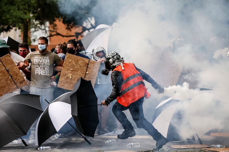 A pro-Palestinian protester hurls a tear-gas canister towards police after it landed among his group at the University of South Florida, in Tampa. AP