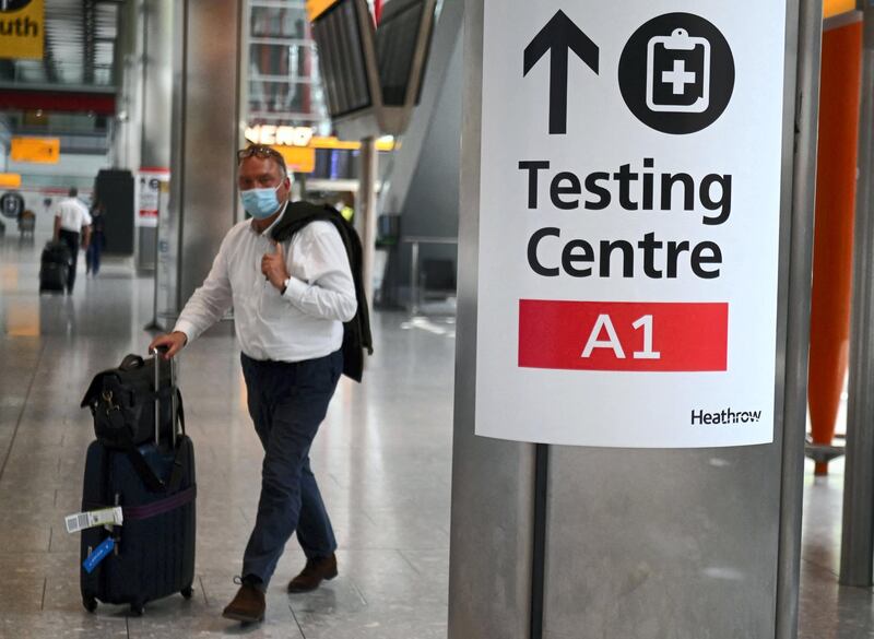 A passenger walks past signage displaying the way to a Covid-19 test centre, in Terminal 5 at Heathrow airport in London, on June 3, 2021. Health Secretary Matt Hancock has said it remains "too early" to say whether all coronavirus restrictions can end on June 21.  Speaking ahead of a G7 health ministers' meeting, he told reporters: "It's too early to say what the decision will be about step four of the road map, which is scheduled to be no earlier than June 21.

 / AFP / DANIEL LEAL-OLIVAS
