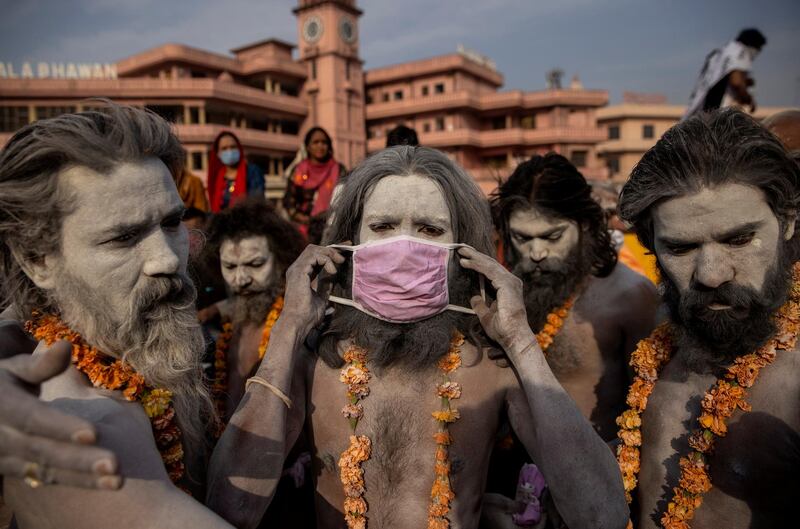 A Naga Sadhu Hindu holy man puts on a face mask before a procession to bathe in the Ganges, during Shahi Snan, at the Kumbh Mela festival, amid the coronavirus pandemic, in Haridwar, northern India. Reuters