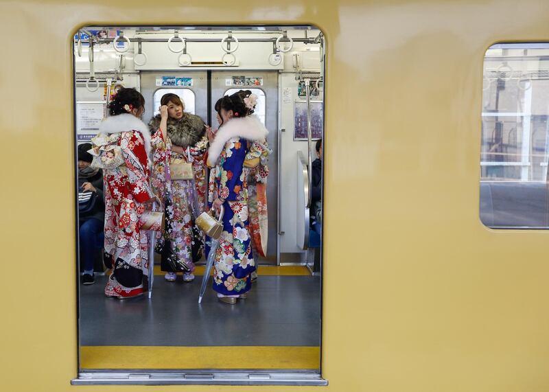 epa06424667 Young Japanese women dressed in colorful kimonos is seen standing inside a train car after attending a ceremony marking the 'Coming of Age Day' at Toshimaen Amusement Park in Tokyo, Japan, 08 January 2018. Coming of Age Day is a celebration for the youth who reach the age of 20 years old, which in Japan, is considered the beginning of adulthood.  EPA/CHRISTOPHER JUE