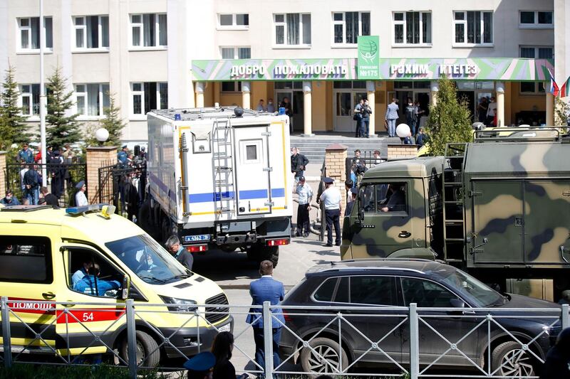 An ambulance and police trucks are parked at a school after a shooting in Kazan. AP Photo