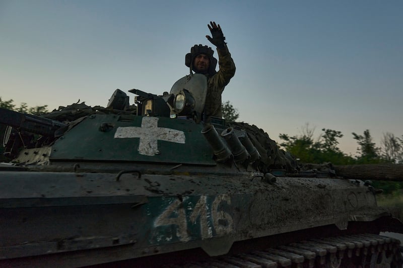 A Ukrainian soldier waves from atop an APC at the front line near Bakhmut in Donetsk region. AP
