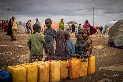 Children sit on water bottles waiting to be filled among tents in a displacement camp in Baidoa, Somalia. Getty Images