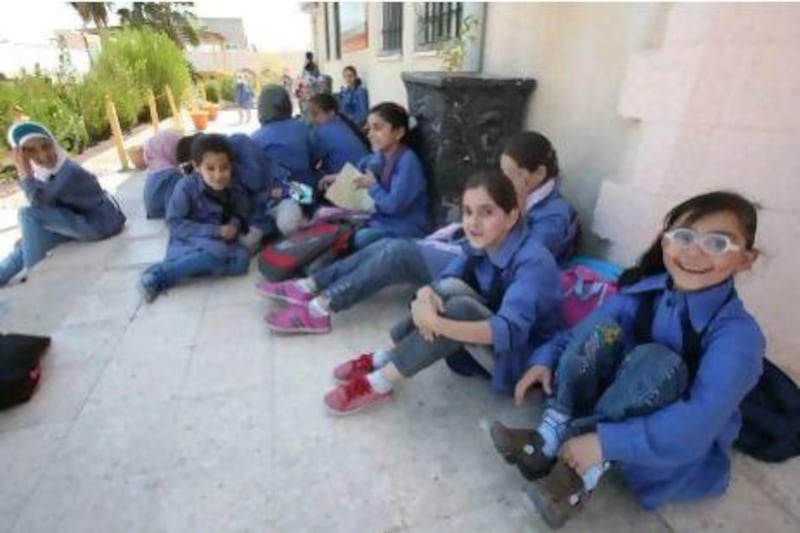 Syrian classmates enjoy a break in the  schoolyard in Jordan.