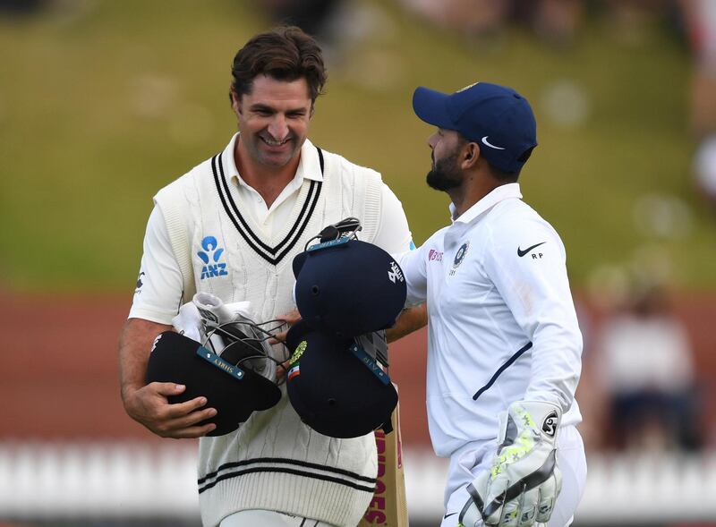 New Zealand's Colin de Grandhomme, left and India's Rishabh Pant share a joke as play ends because of bad light. AP