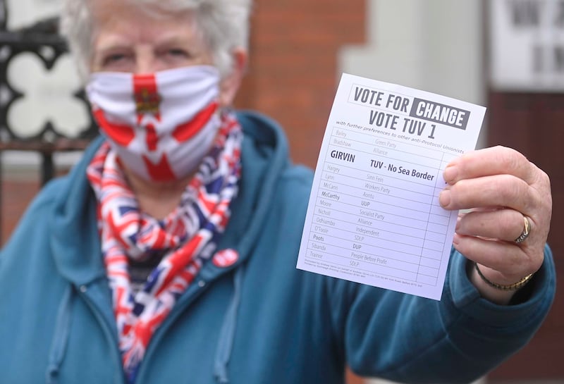 A woman hands out leaflets in support of the Traditional Unionist Voice party in Belfast. EPA