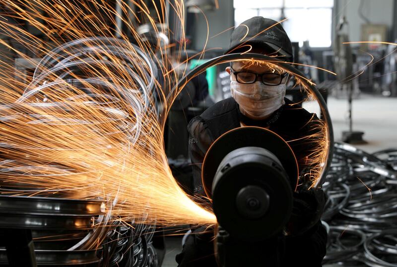 A worker polishes a bicycle steel rim at a factory manufacturing sports equipment in Hangzhou, Zhejiang province, China.  Reuters