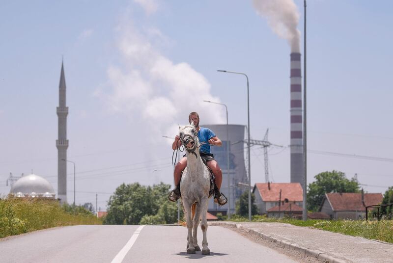 A rider near Kosovo's coal-fired power plant near the town of Obilic. Two coal-fired power plants are the main source of the alarming air pollution levels in Kosovo, and particularly in the town of Obilic, which is between the two plants and near to their ash disposal sites and open-pit lignite mines. AFP