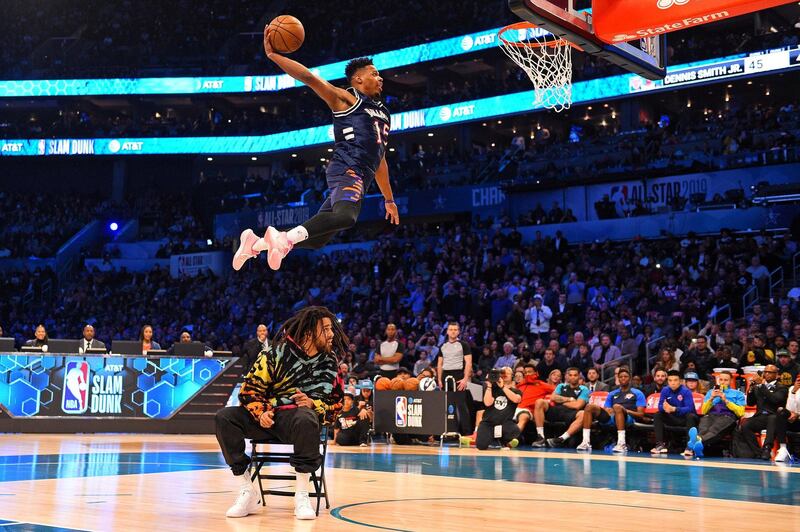 New York Knicks forward Dennis Smith Jr dunks over Recording artist J Cole in the Slam Dunk Contest during the NBA All-Star Saturday Night at Spectrum Center. Bob Donnan-USA TODAY Sports