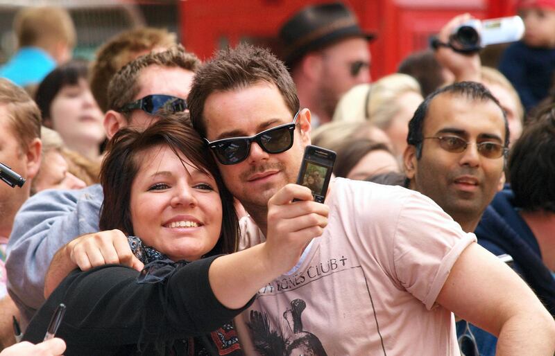 British actor Danny Dyer takes a picture with a fan as he arrives in London's Leicester Square on July 18, 2010 for the British Premiere of Disney/Pixar's new 3D animation movie "Toy Story 3". AFP PHOTO / MAX NASH (Photo by MAX NASH / AFP)
