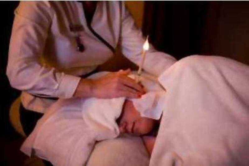 Abu Dhabi - May 20, 2010: Tracy Baldock performs the "ear candling" spa treatment on Barbara Toelen in the Hiltonia Spa at the Hiltonia Beach Club, Corniche. Lauren Lancaster / The National 