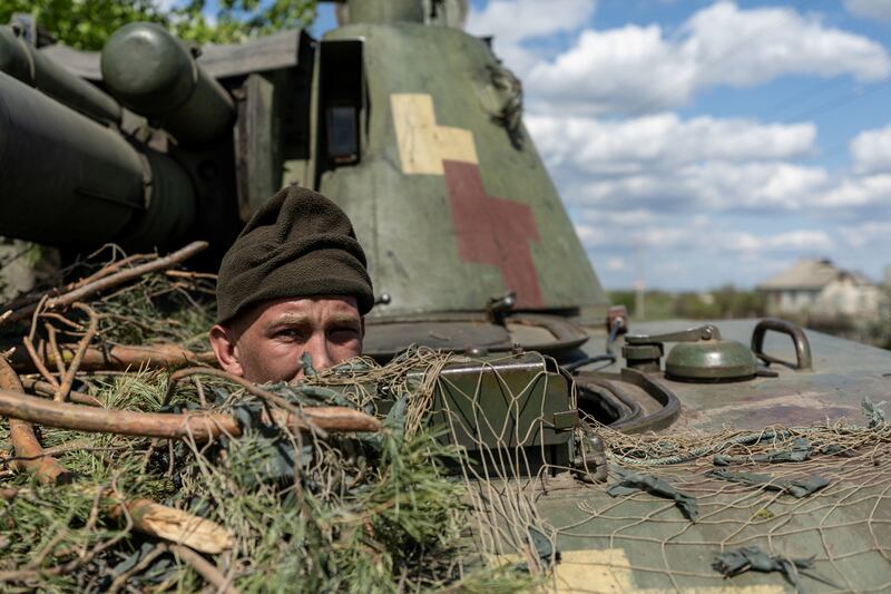 A Ukrainian soldier looks out from a tank in the frontline city of Lyman, part of the Donetsk region. Reuters.