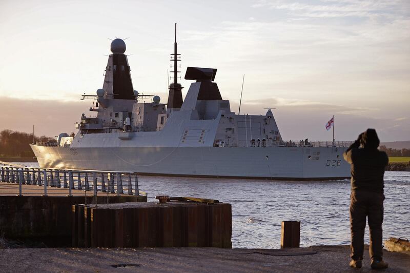 GLASGOW, SCOTLAND - NOVEMBER 29:  An onlooker watches as HMS Defender makes its way up the River Clyde on November 29, 2013 in Glasgow, Scotland. HMS Defender is one of the Royal Navy's new Type 45 destroyers, and has returned to Glasgow where it was built for the first time since becoming a fully fledged member of the fleet and will be open to the public tomorrow.  (Photo by Jeff J Mitchell/Getty Images)