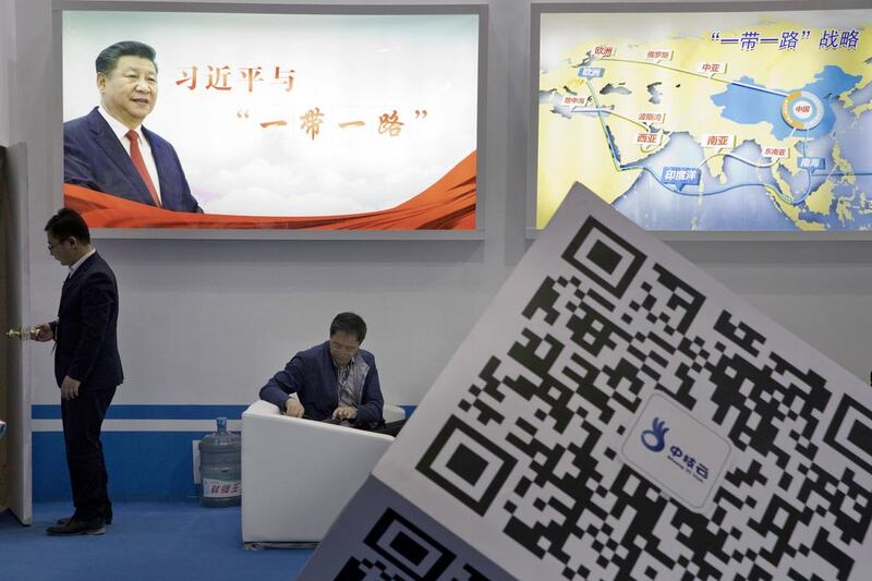 Visitors at a technology conference In Beijing wait near illuminated boards highlighting Chinese President Xi Jinping's Belt and Road Initiative. AP