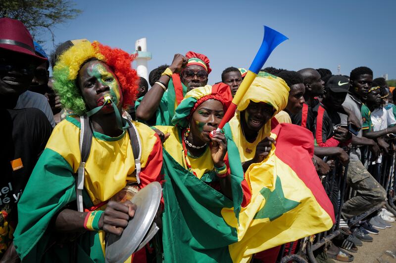 Senegalese fans celebrate as they await the return of their national football team in Dakar on Monday. AP