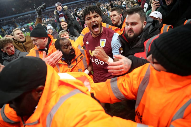 Aston Villa's Tyrone Mings celebrates with fans on the pitch. Reuters