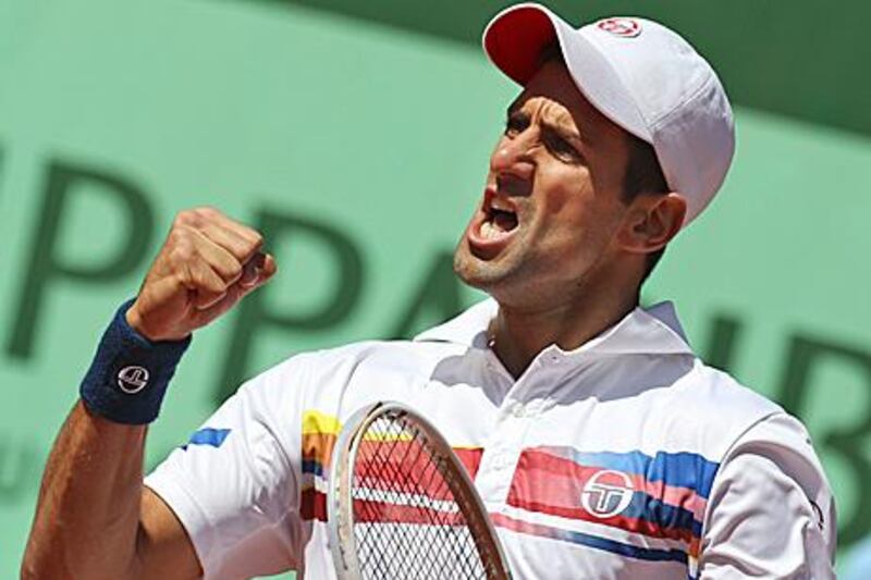 Novak Djokovic clenches his fist in celebration after beating Juan Martin del Potro at Roland Garros.