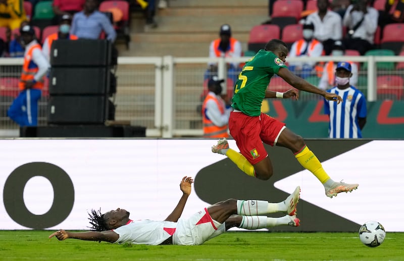 Cameroon's Nouhou Tolo skips over a challenged by Burkina Faso of Issoufou Dayo. AP
