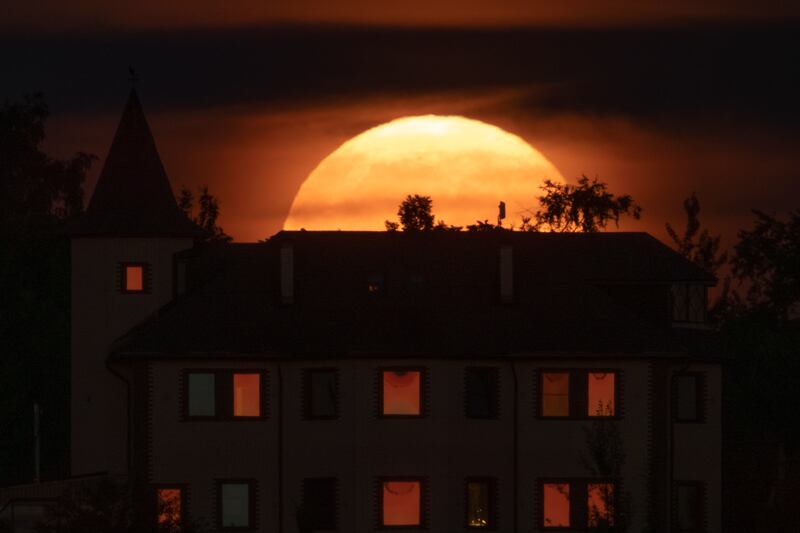 The supermoon rises over a house in the village of Putilovo, near St Petersburg, Russia. AP