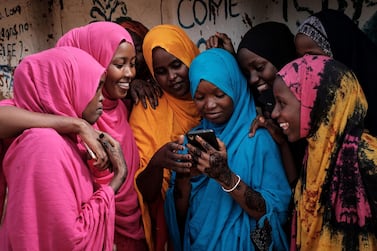 Young Somali refugee women look at a smartphone as they stand together at Dadaab refugee complex, in the north-east of Kenya, on April 16, 2018. - The Dadaab refugee complex which has some 235269 refugees and asylum seekers in four camps about 80kms from the Somali-Kenyan border was established in 1991, according to UNHCR camp population statistics in January 2018. (Photo by Yasuyoshi CHIBA / AFP)