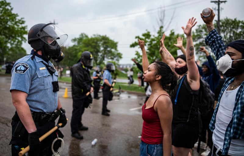 Protesters and police face each other during a rally for George Floyd in Minneapolis on Tuesday, May 26, 2020. Four Minneapolis officers involved in the arrest of the black man who died in police custody were fired Tuesday, hours after a bystanderâ€™s video showed an officer kneeling on the handcuffed manâ€™s neck, even after he pleaded that he could not breathe and stopped moving. (Richard Tsong-Taatarii/Star Tribune via AP)