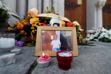 A picture of Vincent Loques, sexton of the Notre Dame church, one of the victims of a deadly knife attack, is seen with candles and flowers in front of the Notre Dame church in Nice, France, October 30, 2020. REUTERS/Eric Gaillard